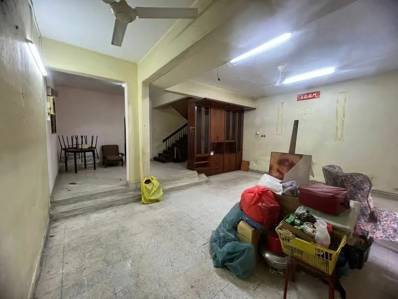 Room features: plain white walls, concrete flooring, ceiling fan, staircase leading to upper floor, wooden cabinetry, dining table with chairs, various storage boxes and bags, exposed light fixtures; style: minimalist.