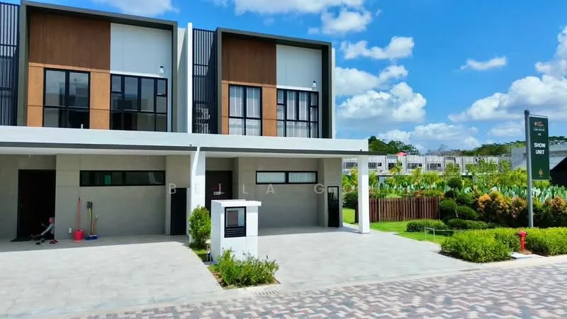 Exterior type: linked terrace house; features: two-storey building, white painted facade, wood panel accents, large windows, manicured lawn, paved driveway, covered car porch, landscaped garden, signage for show unit, surrounded by greenery, clear blue sky; style: modern.