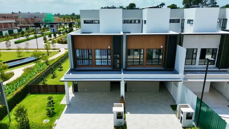 Exterior type: linked terrace house; features: two-storey structure, flat roof, white painted facade, wooden accents on upper level, large windows with black frames, manicured lawn, paved driveway, surrounded by greenery, gated entry, modern architectural style; style: modern.