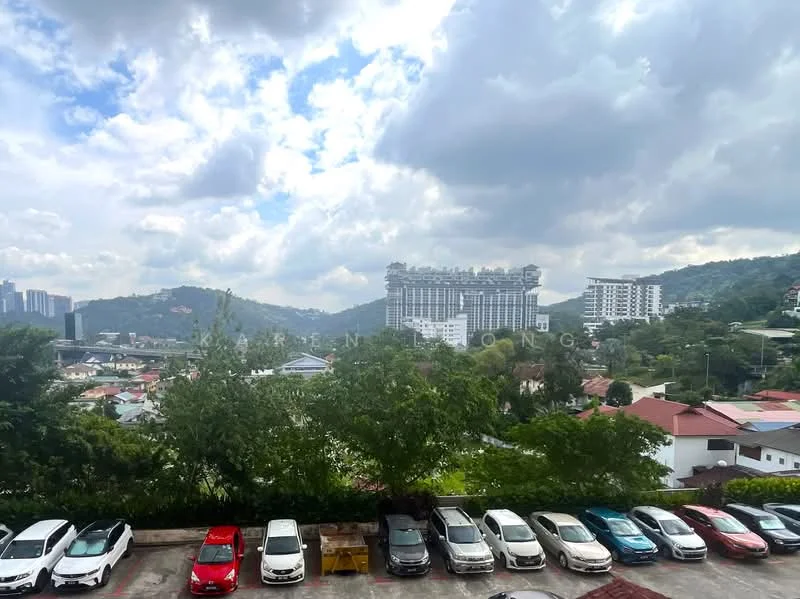Exterior features: city skyline view, surrounded by greenery, parking lot with multiple cars, residential buildings in the background, hills in the distance, cloudy sky.