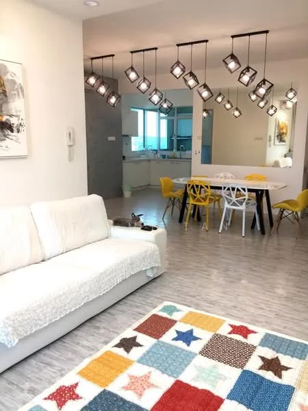 Living features: 3-seater fabric sofa in white, area rug with colorful star pattern, pendant lighting with multiple fixtures, wooden flooring, wall-mounted artwork, floor-to-ceiling windows, dining area visible in background, open layout to kitchen, decorative wall panel, white walls; style: modern; view: city. Dining features: 6-seater dining table in black, white plastic dining chairs, yellow plastic dining chairs, open layout to living area, decorative wall panel, floor-to-ceiling windows; style: modern; view: city. Kitchen features: open kitchen layout, kitchen island, white cabinetry, stainless-steel appliances, countertop with bar seating, greenery visible in background; style: modern; view: city.