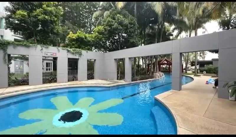 Exterior type: swimming pool deck; features: infinity pool, pool deck with loungers, landscaped garden, palm trees, decorative flower pattern on pool floor, surrounding greenery, covered pavilion, walkway, children's play area; style: modern.