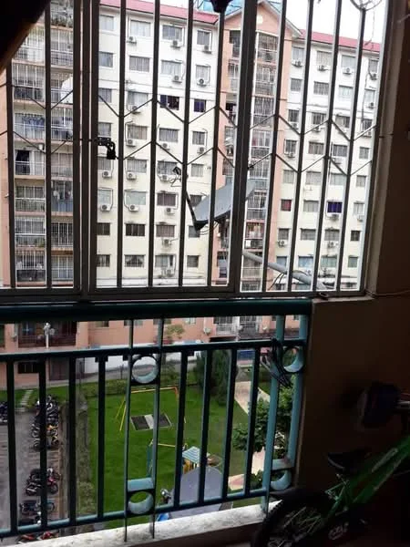 Room features: metal window grill, sliding window, view of courtyard, view of playground, view of parking area, green lawn, bicycle visible, multiple air conditioning units on building facade; view: courtyard.