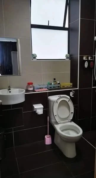 Bathroom features: white ceramic toilet, wall-mounted sink, mirror above sink, brown tiled walls, light beige tiled walls, shower with wall-mounted faucet, toilet paper holder, pink toilet brush, window for natural light, bottles and toiletries on shelf; style: modern.