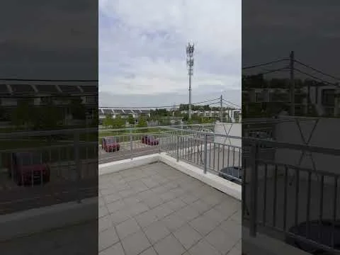 Room features: balcony, grey tiled flooring, metal railing, view of surrounding area, visible telephone tower, open sky, surrounding greenery, nearby parking area; view: city.
