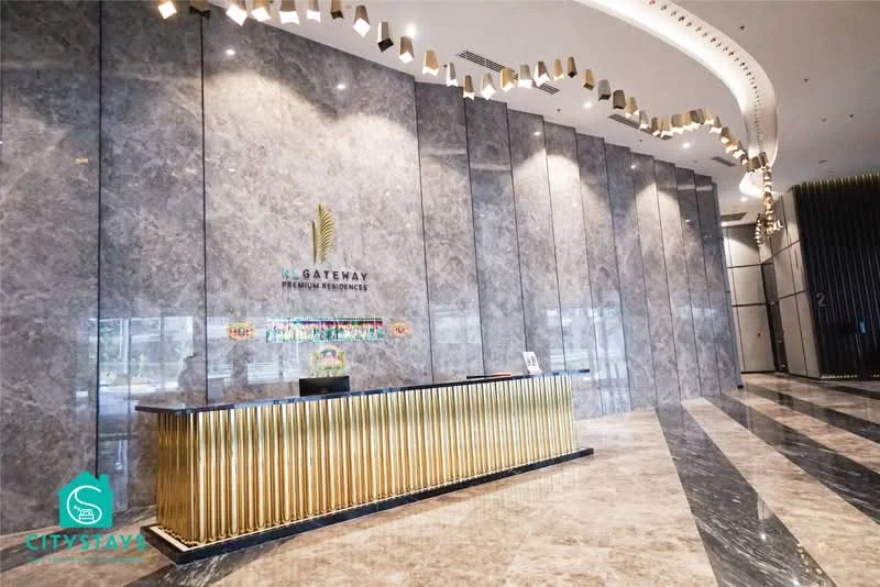 Room features: marble flooring, grey marble feature wall, golden reception counter, backlit signage, modern lighting fixtures, high ceiling, glass windows, decorative ceiling design; style: modern; view: city.