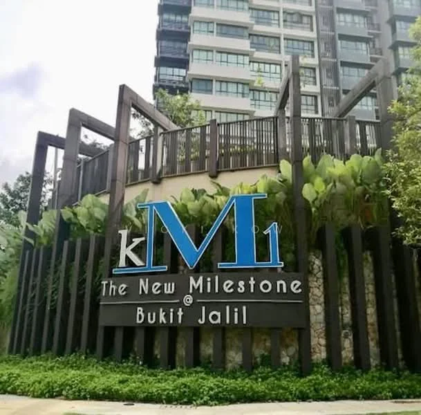Exterior type: high-rise condominium; features: modern facade with greenery, prominent signage, stone cladding, wooden accents, landscaped entrance, surrounding foliage, multiple storeys, balconies visible; style: modern.