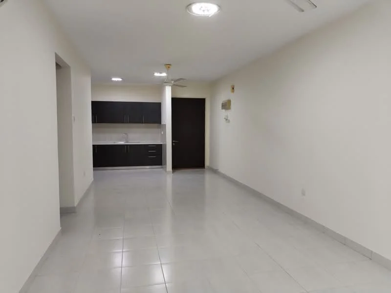 Living features: white painted walls, polished ceramic tile flooring, recessed downlights, 5-blade ceiling fan with light, wall-mounted split AC, kitchenette with dark wood cabinetry, white backsplash, countertop with sink, open layout, neutral color scheme; style: modern.