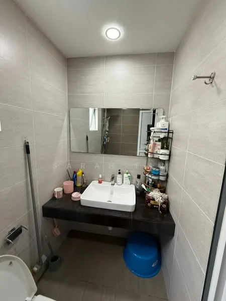 Bathroom features: grey tiled walls, dark countertop, square white sink, framed mirror, wall-mounted shelf, toilet, shower area, recessed lighting, floor tiles, various toiletries, blue stool; style: modern.