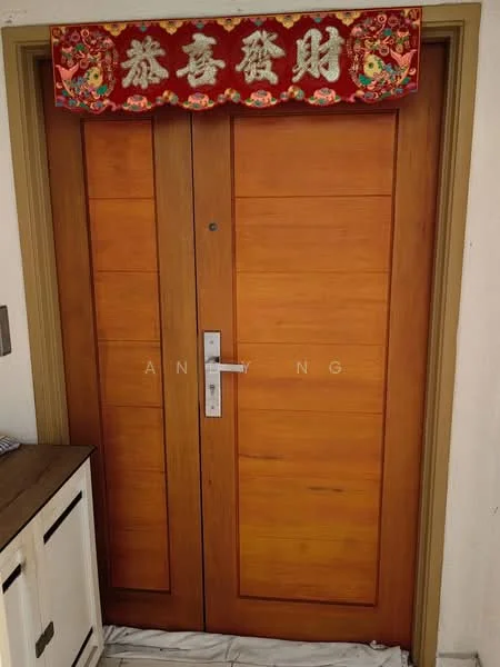 Room features: double wooden doors, natural wood finish, modern door handle, decorative red banner above door, white wall, small console table beside door; style: modern.