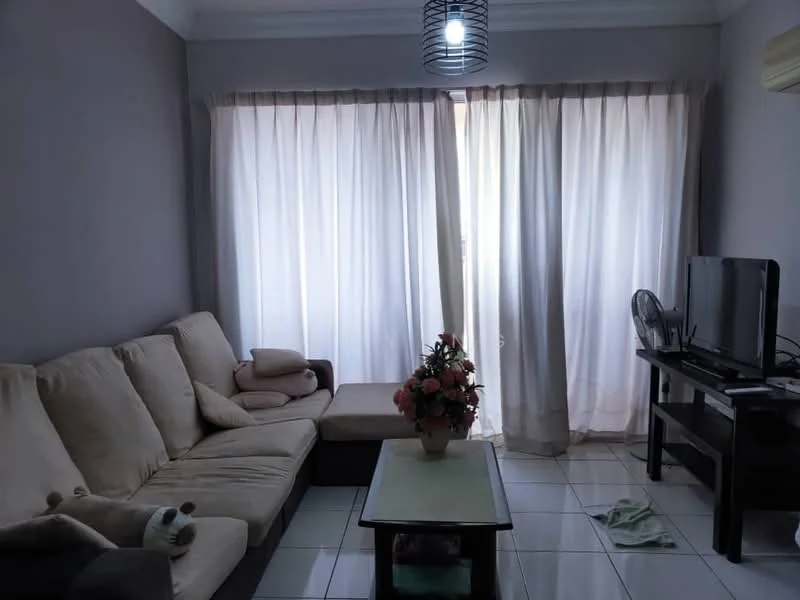 Living features: beige fabric L-shape sectional sofa, coffee table with light wood top, floor-to-ceiling windows with sheer curtains, wall-mounted TV, dark wood TV console, tile flooring, decorative flower arrangement on table, ceiling light fixture, wall-mounted air conditioning unit, area rug; style: contemporary.
