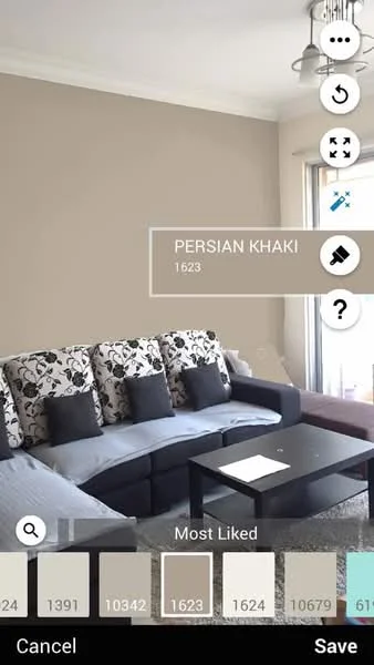 Living features: grey fabric sofa with floral pattern cushions, black coffee table, cream painted walls, ceiling light fixture, laminate flooring, decorative wall art, window with natural light, area rug; style: modern.