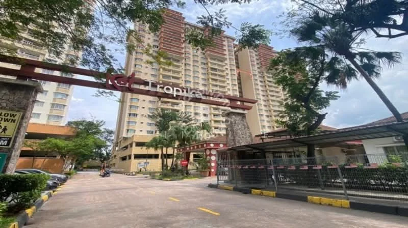 Exterior type: high-rise condominium; features: tall residential building, stone cladding at entrance, landscaped garden with palm trees, manicured lawn, driveway with interlocking pavers, security gate, covered parking area, signage with 'Tropical Vista', surrounded by greenery; style: modern.