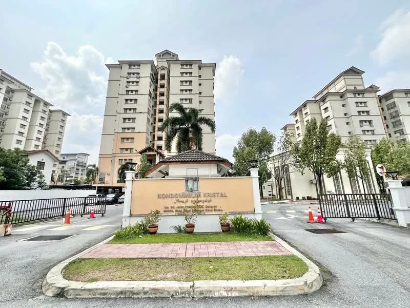 Exterior type: mid-rise condominium; features: cream painted facade, recessed balconies, landscaped entrance with palm trees, manicured lawn, paved walkway, security gate, surrounded by mature greenery; style: modern.