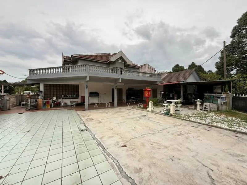 Exterior type: detached bungalow; features: two-storey building, balcony with railing, paved driveway, manicured lawn, outdoor seating area, garden space, roof overhang, multiple entrances, surrounded by greenery, open parking area; style: traditional.