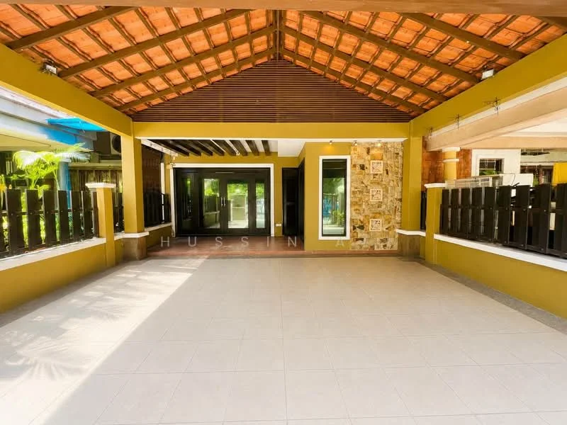 Exterior type: detached bungalow; features: open-air porch, exposed wooden beams, terracotta tile roof, stone cladding on walls, large glass sliding doors, tiled flooring, surrounding greenery, decorative stone features, high ceiling, fenced perimeter; style: modern.