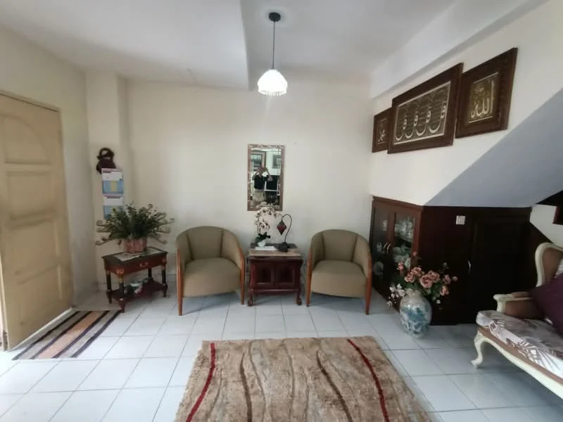 Living features: white painted walls, ceramic tile flooring, recessed ceiling with pendant light, two armchairs in beige upholstery, wooden side table, decorative mirror, wooden cabinet with glass doors, decorative vase with flowers, area rug with geometric pattern, framed artwork on wall, potted plant, wall-mounted decorative items; style: traditional.