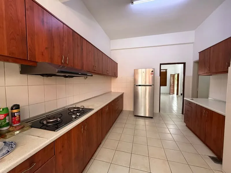 Kitchen features: brown wooden cabinets, white tiled backsplash, light-colored countertop, stainless-steel fridge, built-in gas hob with two burners, exhaust hood, ceramic tile flooring, single-bowl stainless-steel sink; style: modern.