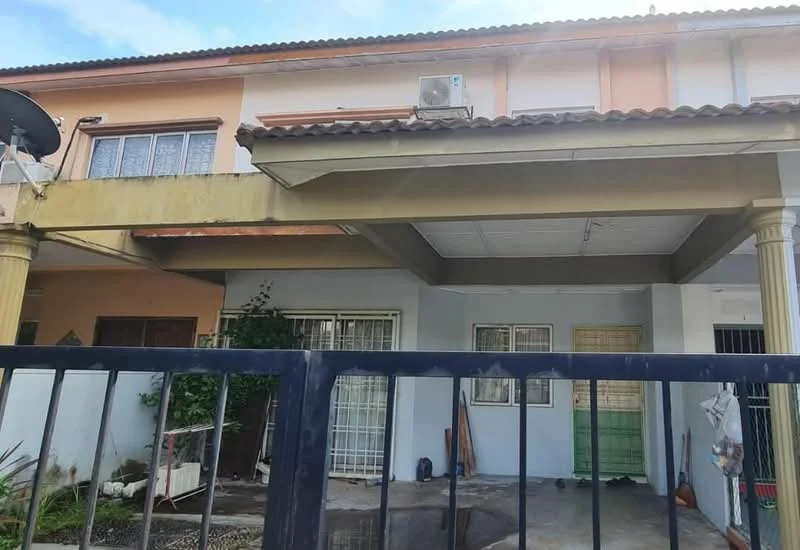 Exterior type: linked terrace house; features: flat roof, cream painted facade, columns at entrance, visible air conditioning unit, fenced front yard, paved walkway, garden area with plants, two-tone exterior paint, windows with grilles, satellite dish on roof; style: modern.