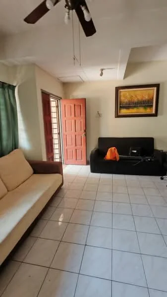Living features: cream painted walls, white tiled flooring, 5-blade ceiling fan, sofa in beige fabric, black fabric sofa, wooden door, framed artwork on wall, green curtains, electronic equipment on floor.