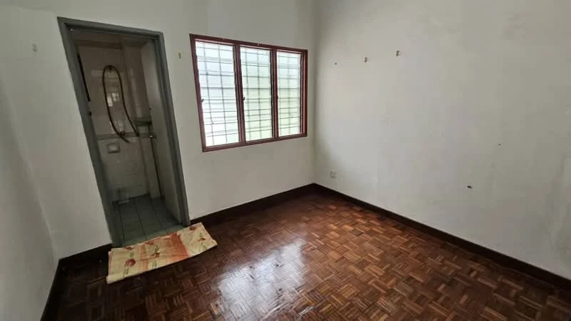 Room features: white painted walls, parquet wood flooring, window with grid pattern, bathroom door, tiled flooring in bathroom, shower head visible, floor mat.