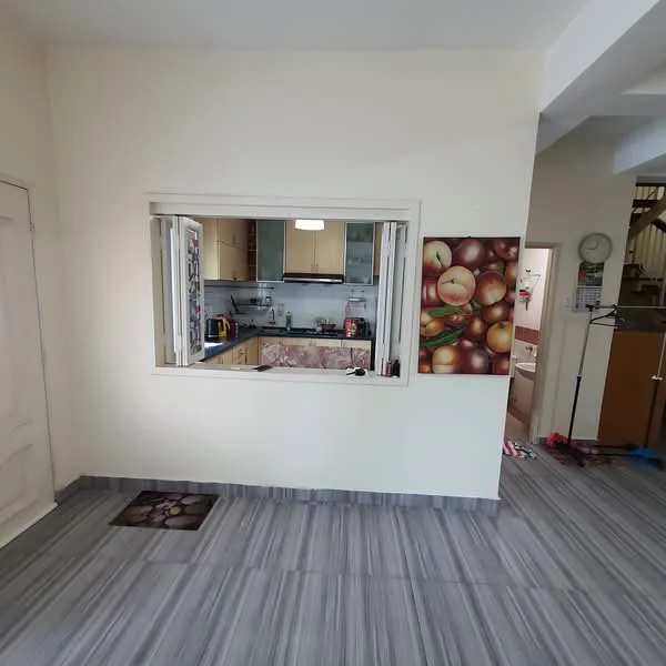 Kitchen features: white painted walls, grey tiled flooring, window with sliding glass, kitchen counter with cabinets, built-in appliances, decorative wall art with fruit theme, open layout to living area, overhead lighting fixture; style: modern. Room features: grey tiled flooring, white painted walls, door leading to another room, wall clock.