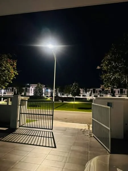 Exterior type: linked terrace house; features: gated entrance, paved driveway, street lighting, manicured lawn, surrounding greenery, nighttime view, front yard, adjacent road; style: modern.