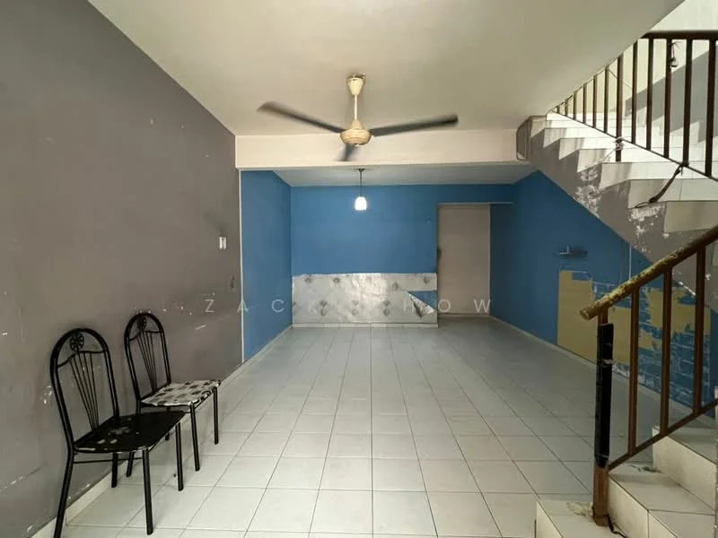 Living features: white tiled flooring, grey painted walls, blue accent wall, ceiling fan, single pendant light, staircase with wooden railing, two black chairs, wall with tile cladding, open layout.