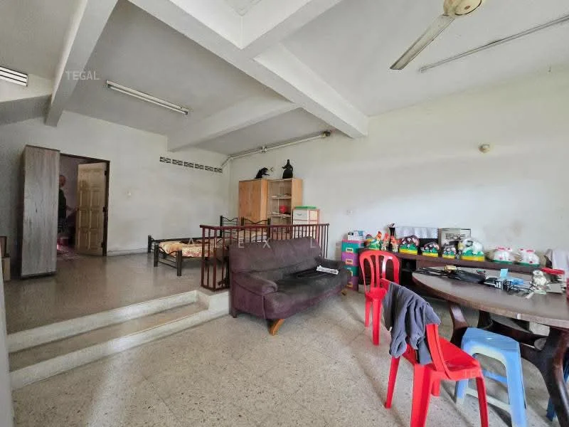 Living features: exposed beams on ceiling, ceiling fan, light grey walls, terrazzo flooring, 3-seater fabric sofa in dark brown, wooden coffee table, dining table with red plastic chairs, wooden cabinet, toys and decorative items on shelves.