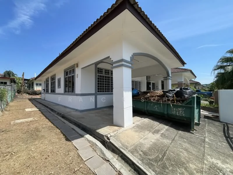 Exterior type: detached bungalow; features: white painted facade, flat roof, single-storey, arched entrance, large windows, concrete walkway, manicured lawn, surrounded by greenery, dumpster visible, unfinished landscaping; style: modern.