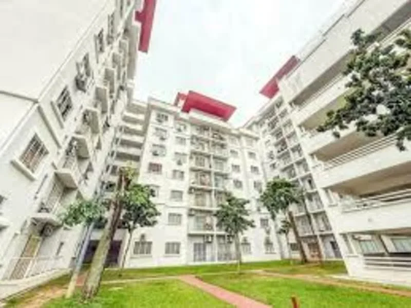 Exterior type: low-rise apartment block; features: white painted facade, flat roof with red accents, approximately 5-storey building, manicured lawn, landscaped garden area, paved walkway, balconies on upper floors, large windows, trees surrounding the building; style: modern.