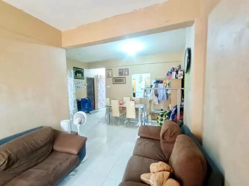 Living features: brown fabric sofa, light-colored walls, white tiled flooring, ceiling light fixture, floor fan, decorative wall clock, open layout to dining area, window with no visible treatment. Dining features: glass dining table, four dining chairs, wall-mounted shelves, decorative items on shelves, laundry hanging in background.