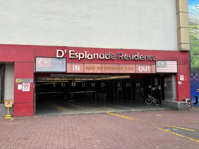 Exterior type: parking deck; features: entrance sign with 'D' Esplanade Residence', clearance height of 2.0m, visible parking spaces, paved driveway, security signage, bicycle rack, flag of Turkey, flag of Malaysia; style: modern.