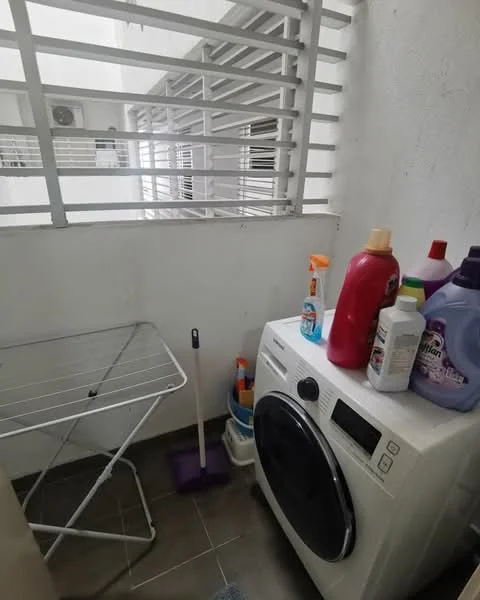 Laundry features: front-load washing machine, clothes drying rack, cleaning supplies, broom, mop, tile flooring, white painted walls, window with security bars, shelf for storage.