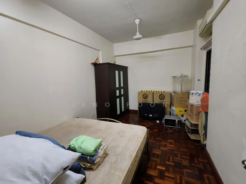 Bedroom features: wooden flooring, white painted walls, ceiling fan, double bed, bedding with pillows, green and blue towels, wardrobe with sliding doors, cardboard boxes, plastic water container, small shelving unit.