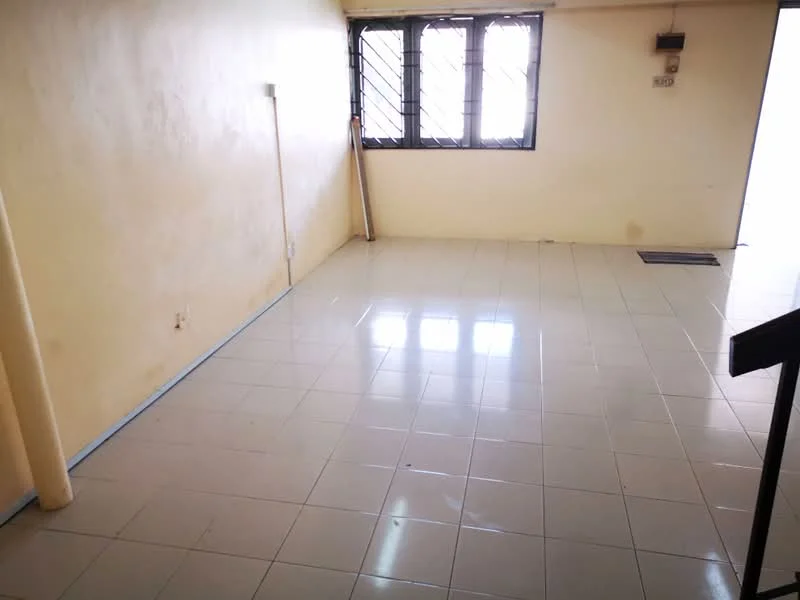 Room features: cream painted walls, glossy ceramic tile flooring, large windows with metal grills, natural light from windows, corner column, doorway leading to another space, no visible furniture, clean and uncluttered space.