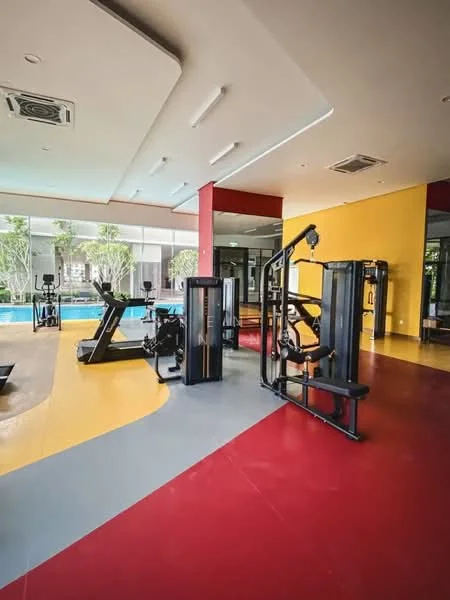 Room features: gym equipment, treadmill, multi-station weight machine, exercise bike, large windows, pool view, yellow and red flooring, air conditioning unit, recessed lighting, open layout; style: modern; view: pool.