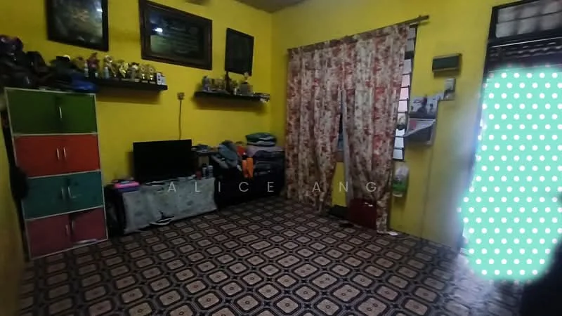 Room features: yellow painted walls, tiled flooring with geometric pattern, curtains with floral pattern, shelves with trophies, television, green and red storage cabinet, stacked clothing, window with grid pattern, decorative items on shelves; style: traditional.