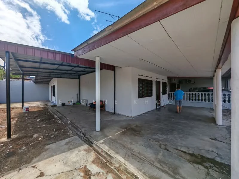 Exterior type: detached bungalow; features: flat roof, white painted facade, concrete flooring, covered patio area, exposed beams, metal awning, manicured lawn, surrounded by greenery; style: modern.