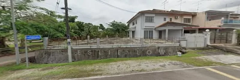 Exterior type: detached bungalow; features: two-storey building, concrete facade, fenced perimeter, manicured lawn, paved driveway, surrounded by greenery, visible utility poles, adjacent to road; style: modern.