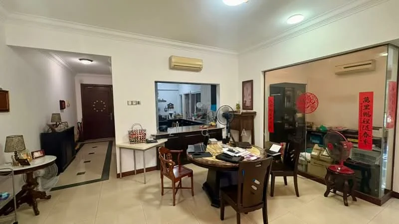 Room features: cream painted walls, white ceiling with recessed lighting, tile flooring, round dining table, 4 wooden dining chairs, decorative wall clock, table lamp on side table, fan on table, glass partition, decorative items on shelves, Chinese calligraphy decorations, open kitchen area visible in background; style: traditional.