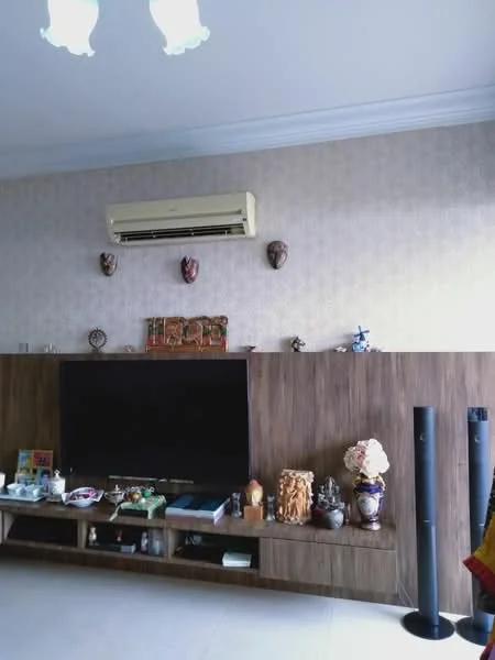 Living features: wall-mounted split AC, flat-screen TV, wooden TV console, decorative masks on wall, ceramic decorative items, shelves with various ornaments, light-colored wallpaper, crown moulding, neutral tile flooring; style: modern.