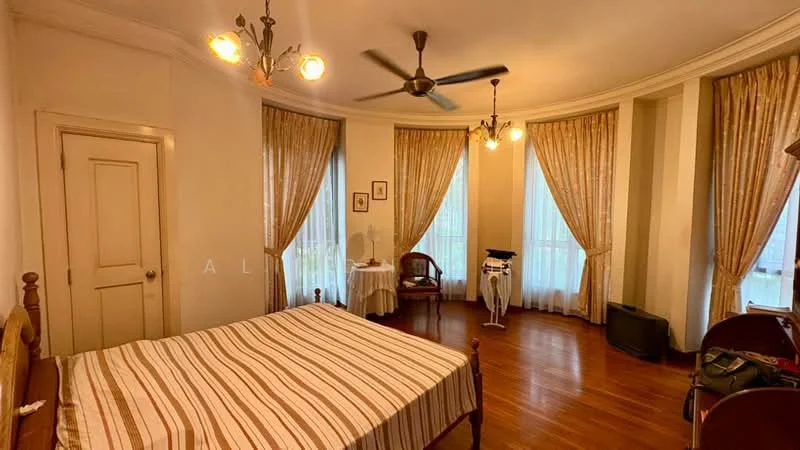 Bedroom features: wooden flooring, white painted walls, tray ceiling, 3-blade ceiling fan, 2 large windows with sheer curtains, striped bedspread, wooden bed frame, wooden chair, small round table, ironing board, decorative wall art, wall-mounted mirror; style: traditional.