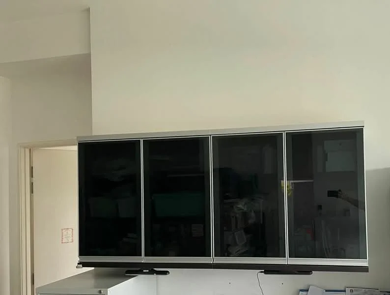 Room features: wall-mounted cabinetry with glass doors, metal frame, black glass panels, white walls, minimalist design; style: modern.