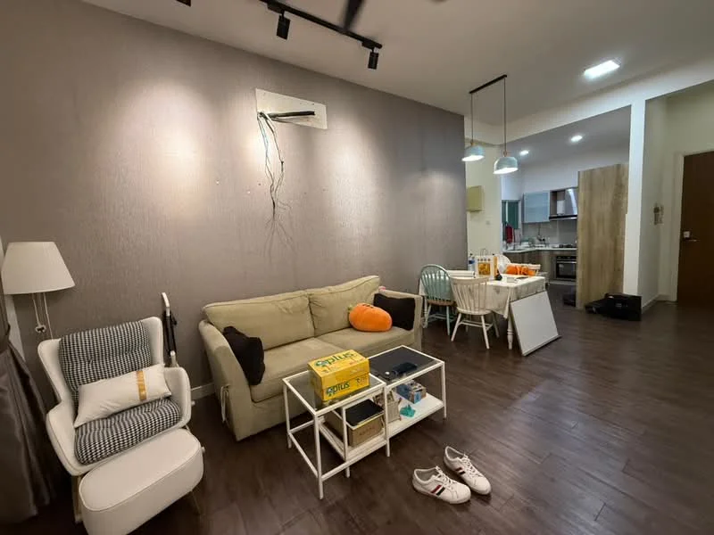 Living features: light brown wooden flooring, grey accent wall, white ceiling, 5-blade ceiling fan with light, sofa in light beige, white coffee table, decorative pillows in orange, dining table with chairs, wall-mounted air conditioning unit, area rug, sliding door to kitchen, decorative items on coffee table; style: modern. Kitchen features: open kitchen layout, wood cabinetry, stainless-steel appliances, countertop with bar seating, kitchen sink, oven, stove, refrigerator; style: modern.