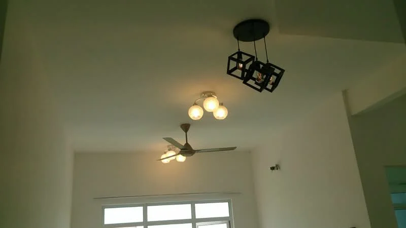 Room features: white painted walls, ceiling fan, 3-blade ceiling fan, pendant light with geometric design, 3-bulb light fixture, large window, natural light.