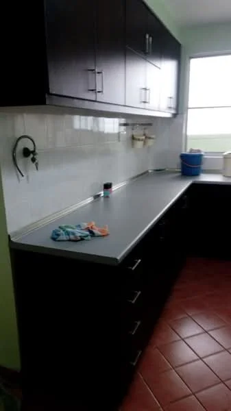 Kitchen features: dark wood cabinetry, grey laminate countertop, white tiled backsplash, single-bowl stainless-steel sink, chrome faucet, window with view, red terracotta tile flooring, kitchen towels, cleaning bucket; style: modern.