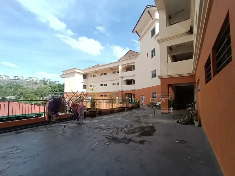Exterior type: low-rise apartment block; features: orange painted facade, flat roof, manicured lawn, potted plants, clothes drying rack, concrete walkway, surrounded by greenery, multiple storeys, balconies visible, parking area; style: modern.