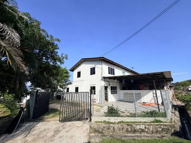 Exterior type: detached bungalow; features: white painted facade, flat roof, single-storey, fenced perimeter, gated entry, concrete driveway, landscaped garden area, surrounded by greenery; style: modern.