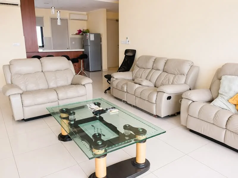 Living features: 2 beige leather recliner sofas, 1 glass coffee table with black and gold base, white tiled flooring, cream painted walls, 1 wall-mounted split AC, floor-to-ceiling window with sheer curtains, decorative items on coffee table, black ergonomic office chair, open layout to kitchen area; style: modern.